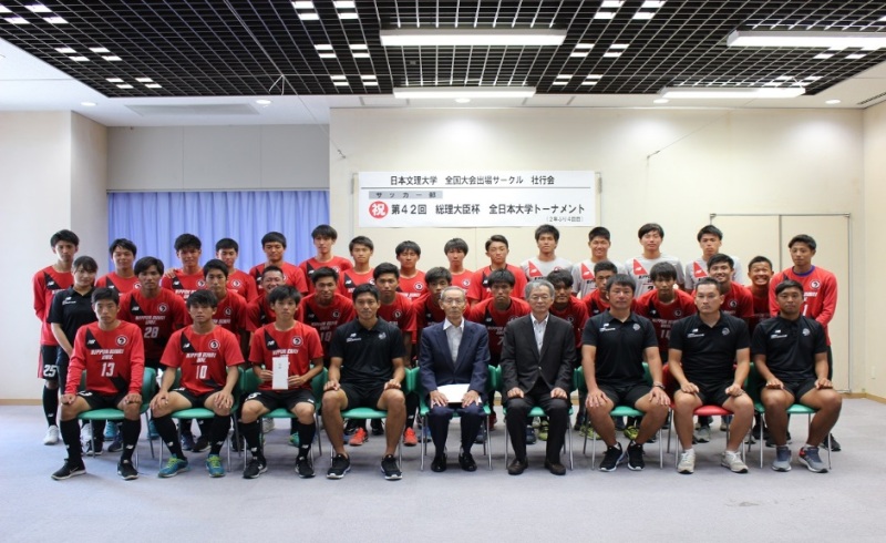 島岡副学長（前列中央右）、村山会長（同中央）とサッカー部指導者、選手たち