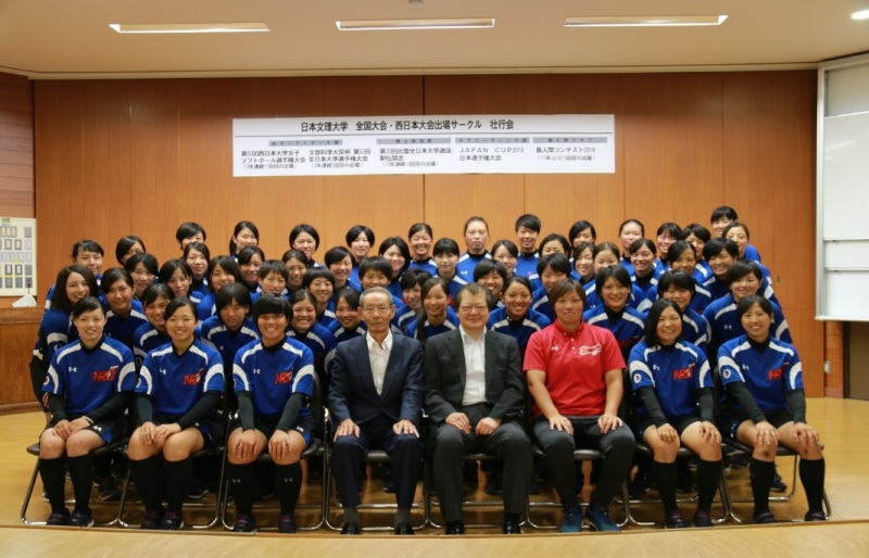 菅学長（中央右）、村山会長（同左）と女子ソフトボール部指導者、部員たち。